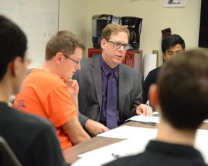 Gary Weiss, director of the Wireless Sensor Data Mining Lab, works with his students to integrate their Actitracker app into smartwatches. (Photo by Joanna Mercuri)