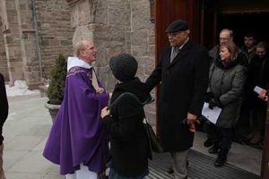 Father McShane greets worshipers outside the Rose Hill Church after mass.