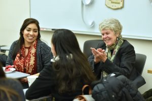 Sandra Turner and Mentoring Latinas mentor Kathryn Madigan talk with mentees during a holiday party at Fordham College at Rose Hill. Photo by Dana Maxson. 