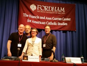 Thomas Kelly, Tom Fontana, Karin Coonrod, and panel moderator George Drance, S.J.  pose for a picture from the stage.
