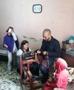 MBA student Dominic Swain, whose team served as consultants to Azul Solidario, spins yarn from sheep’s wool with help from an Argentinian weaver