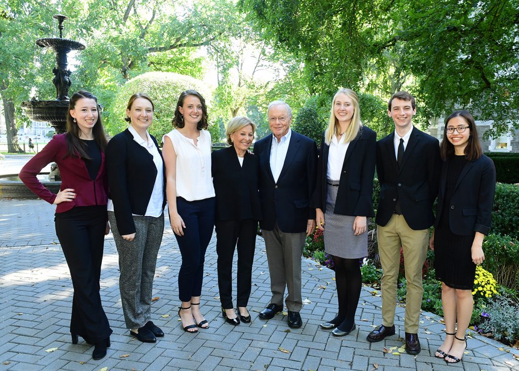 Rose O'Neill, Natalie Grammer, Lucie Taylor, Maurice J. (Mo) Cunniffe, FCRH ’54, Carolyn Dursi Cunniffe, Ph.D., GSAS ’71, Erin O'Rourk, Andrew Souther, and Ashley Conde pose for a picture in front of the fountain on the Rose Hill campus