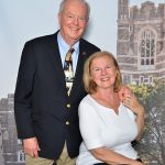 Alumni couple pose for a picture in front of a cut out of Keating Hall