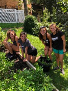 Four students stand together in a garden in the Bronx.