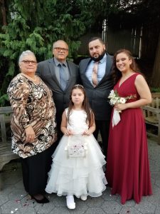 Martinez standing with her husband, son, daughter, and granddaughter at a 2018 wedding. 