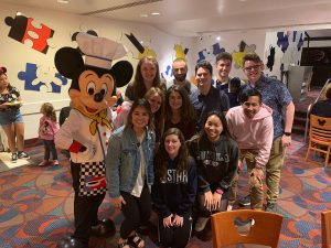 Gabelli students pose for a picture with Mickey Mouse 