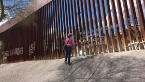 A person looks at a barrier seperating Mexico from the United States