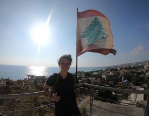 Samantha Slattery standing in front of a flag in Lebanon.