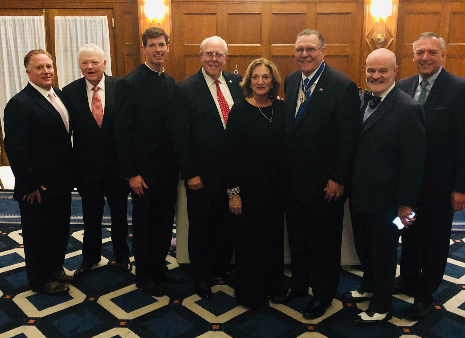 group photo of Fordham alumni attending a reception following the awarding of the Medal of Freedom to retired General Jack Keane