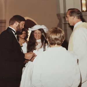 A groom, bride, and other people standing in a circle