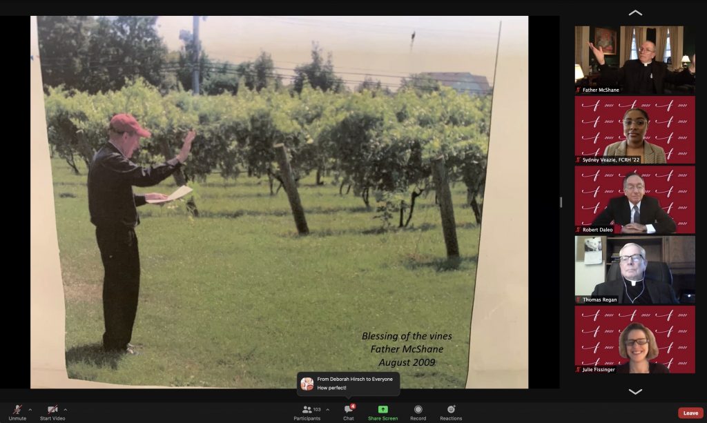 A man standing in front of a vineyard with a book