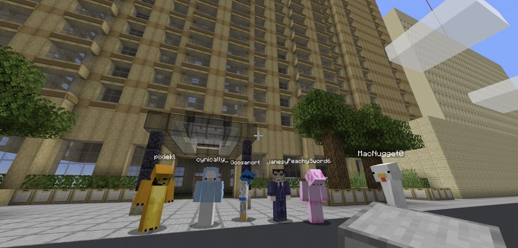 Five video game avatars with a blocky texture stand in front of a digital building.