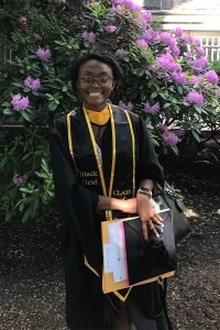 Darlyn Smith, a 2021 GSE graduate, posing in front of flowers.