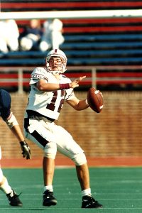 Joe Moorhead throwing football as quarterback for Fordham Rams.