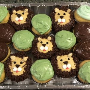 Cupcakes that are green, brown, or decorated with the face of a lion
